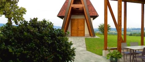 A modern building with a triangular roof and a wooden door.