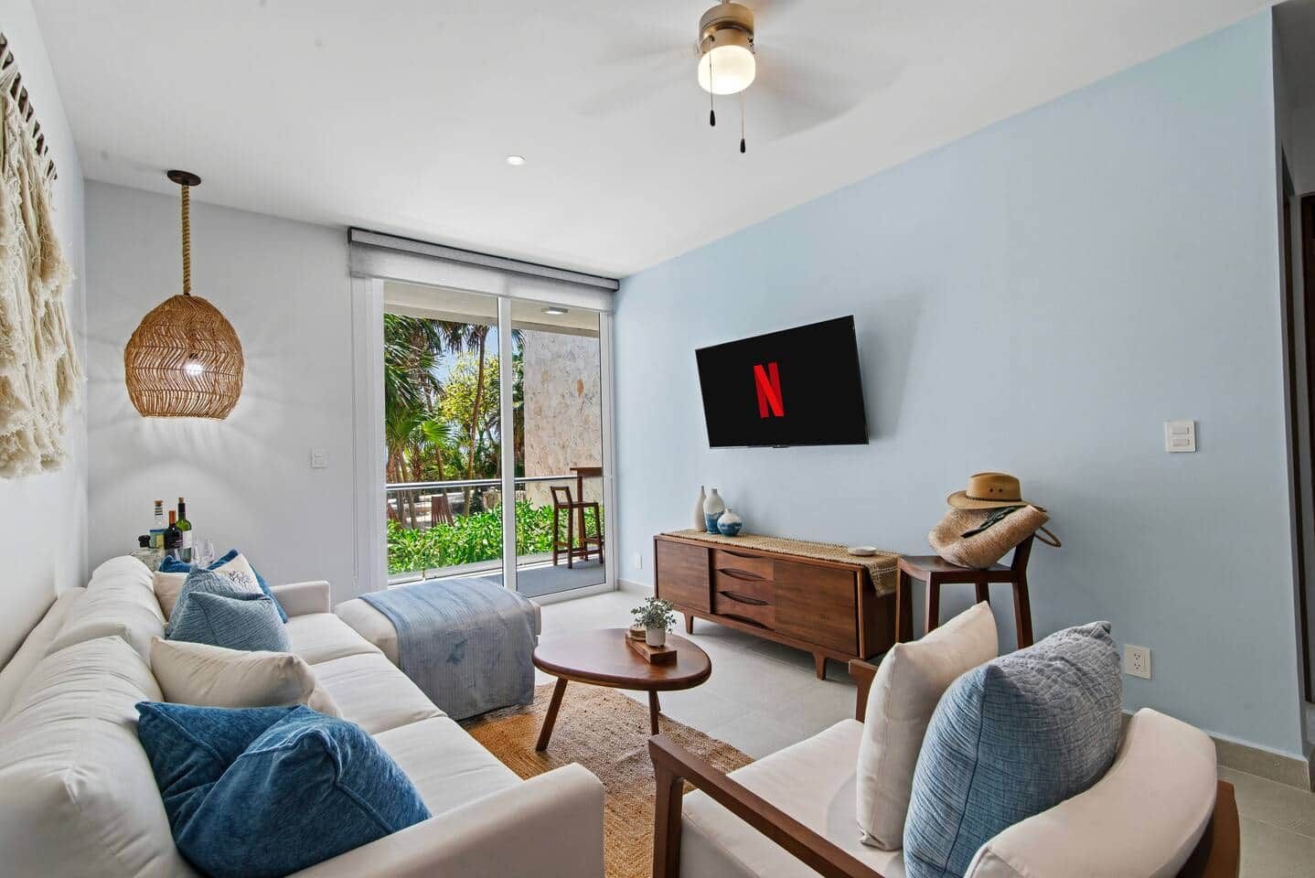 A modern living room with a sofa set, a coffee table, and a TV mounted on the wall.
