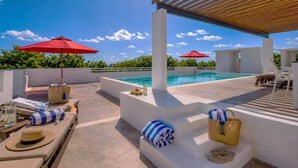 A rooftop pool area with lounge chairs, umbrellas, and a clear view of the sky. - Akumal Bosque | 8 Min Walk To Beach | Rooftop Pool (Grand Sirenis)