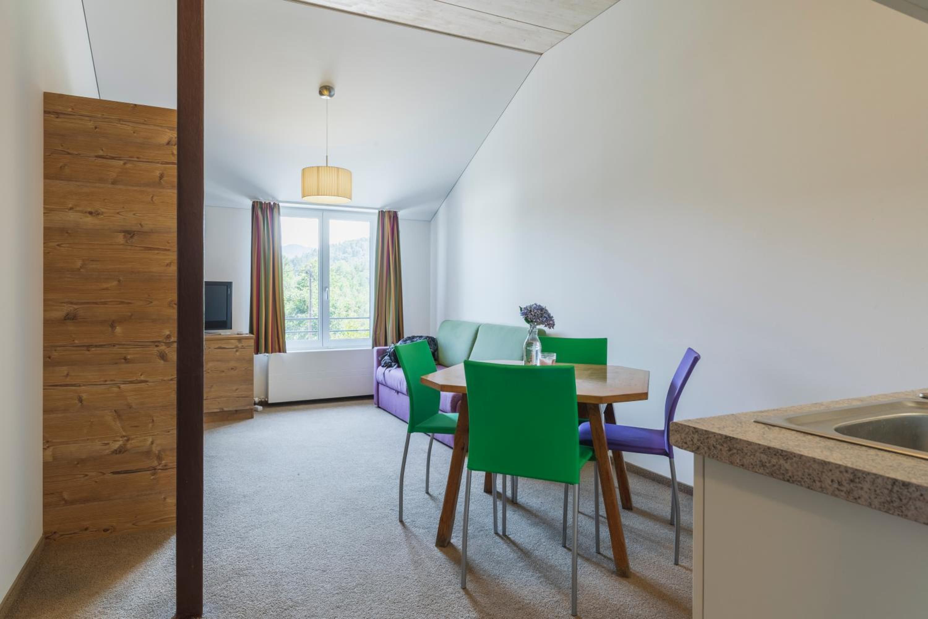 Eine moderne Küche mit Essbereich, einem fensterbepflanzten Fenster und Blick auf Grünflächen.
