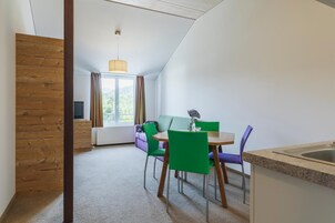 Una cocina moderna con comedor, una ventana con cortinas y vistas a zonas verdes.