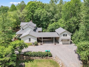 A two-story house with a covered garage and a driveway. - Private 7-Acre Luxury Knoxville Retreat. Sleeps 14. Theater + Game Room (Knoxville)