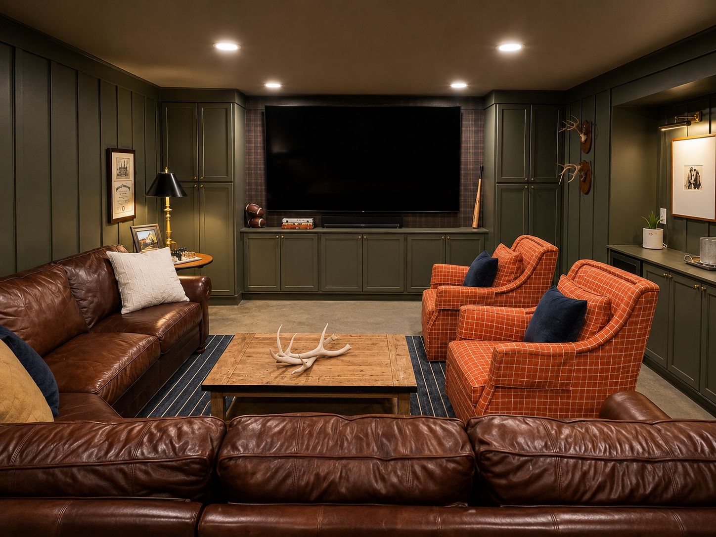 A living room with a brown leather sofa, an orange plaid sofa, and a wooden coffee table with antlers.