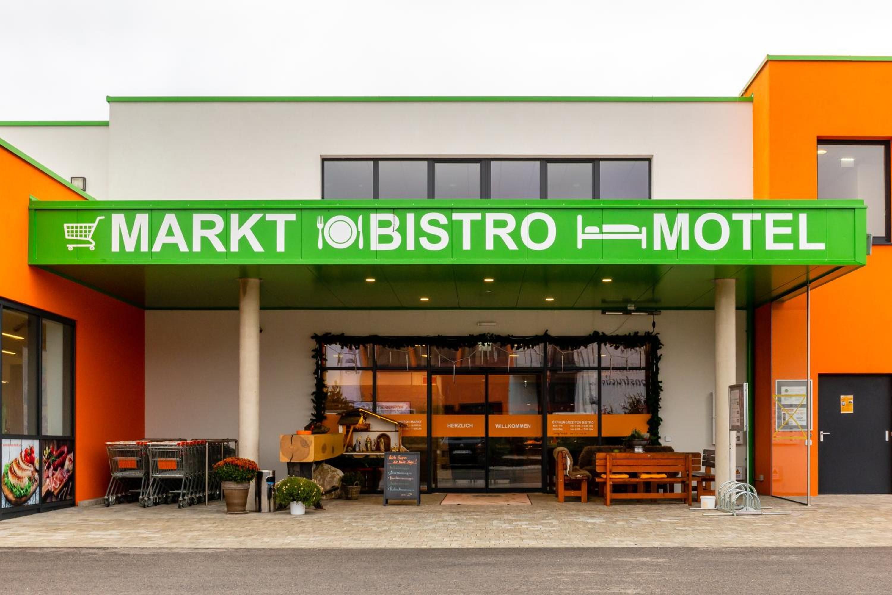 A building with a green sign indicating it is a market, bistro, and motel.