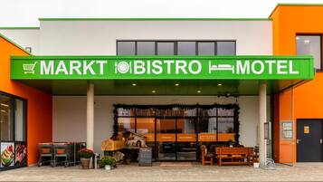 A building with a green sign indicating it is a market, bistro, and motel.