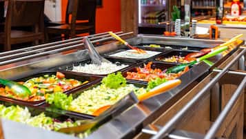 A buffet with various food options including rice, salads, and vegetables.
