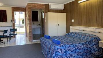 Een slaapkamer met een bed, een kledingkast, een bureau en een stoel.