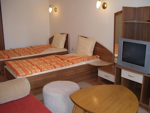 A room with two single beds, a television, and a small table. - Kestenite Family Hotel (Samokov)
