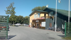 Un área de recepción con un cartel, un edificio con techo verde y una fila de bicicletas estacionadas.