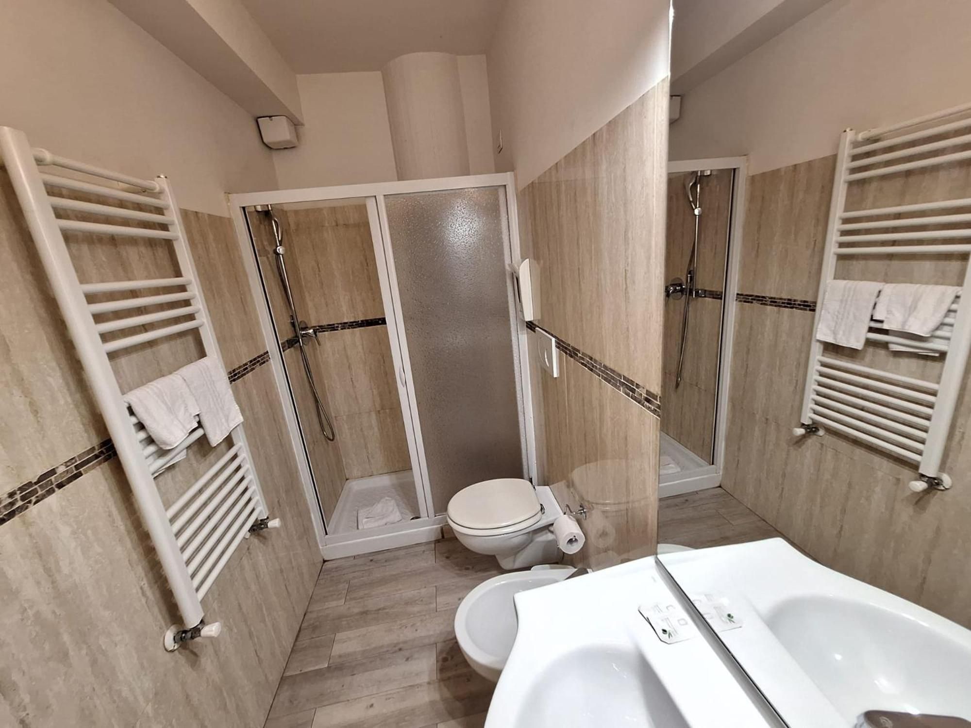 Une salle de bain avec douche, toilettes et baignoire.