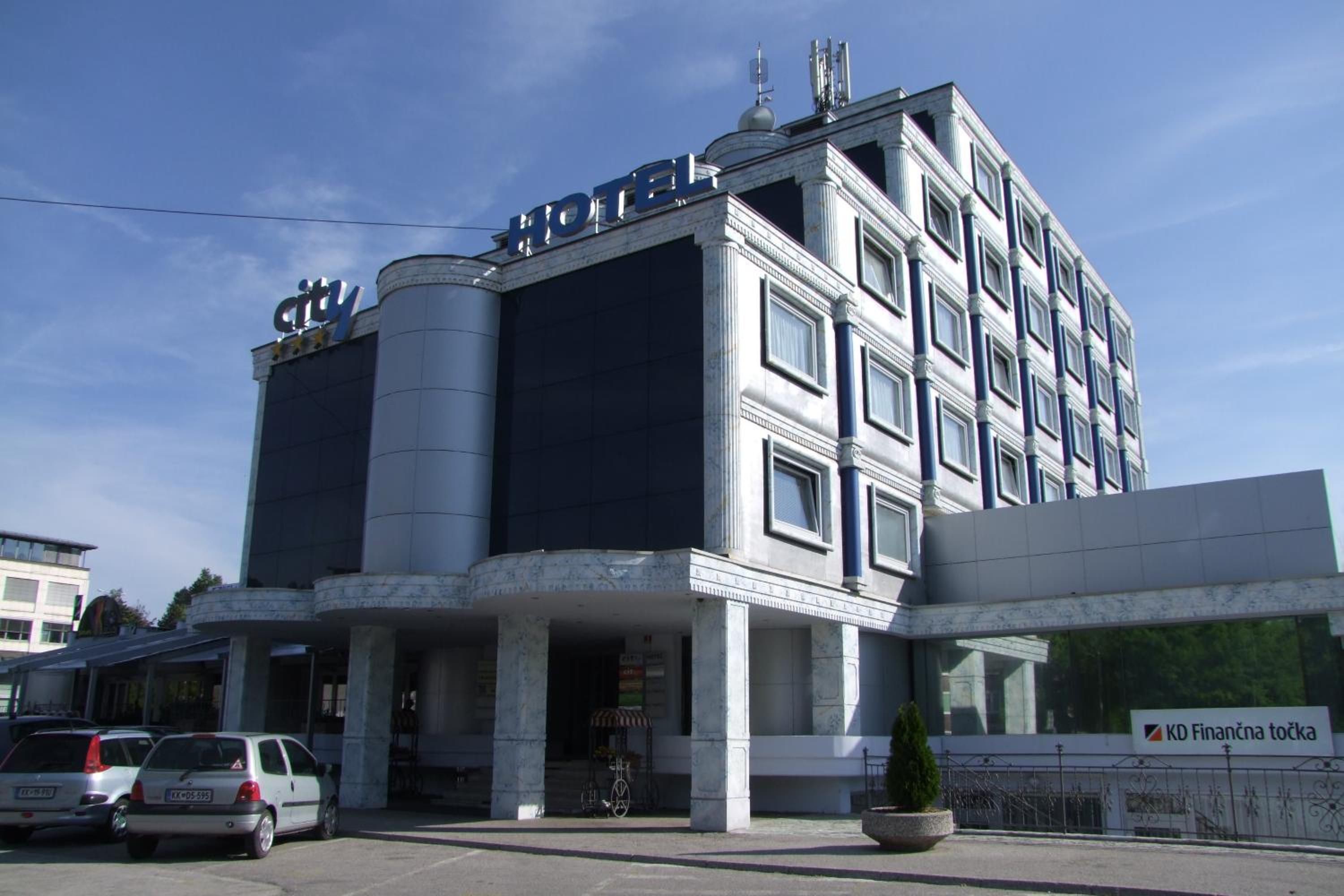 A hotel with a modern facade, a prominent 'HOTEL' sign, and a 'city' sign above the entrance.