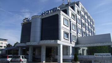 A hotel with a modern facade, a prominent 'HOTEL' sign, and a 'city' sign above the entrance.