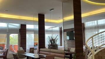 A modern interior with a dining area, seating, and a staircase.