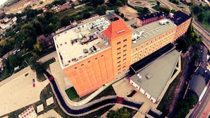 A large building with multiple floors, a parking lot, and a landscaped area with pathways. - Hostel Mi Odzynarodowe Centrum Spotka N M Codzie Y (Torun)