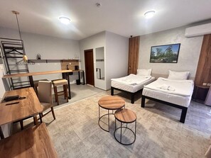 A modern hotel room with a bed, a desk, and a chair. There is a small round table in the center. - Clepsydra Residence (Plovdiv)