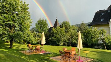 A garden with outdoor furniture and a rainbow.