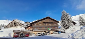 Un hotel de varios pisos con balcones, habitaciones privadas y un paisaje de estación de esquí.
