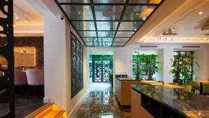 Um interior moderno com cozinha, área de refeições e corredor que leva a uma estufa.