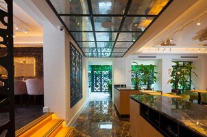 Un interior moderno con zona de cocina, comedor y un pasillo que conduce a un invernadero.