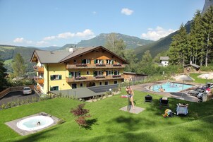 A two-story building with a swimming pool and outdoor seating.