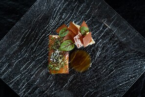 Un plato cuadrado con una superficie oscura y texturizada.