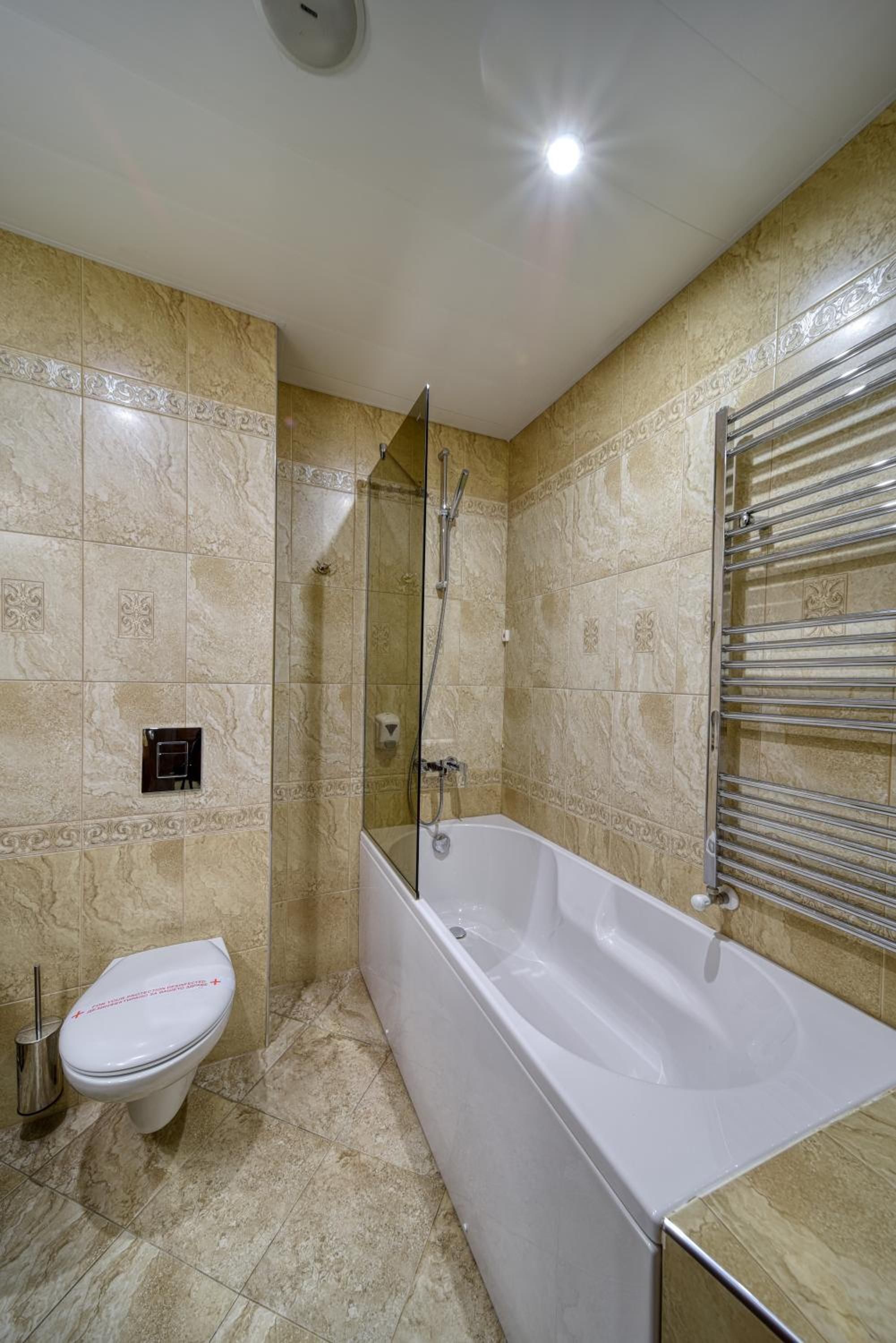 A bathroom with a bathtub, toilet, and shower area.