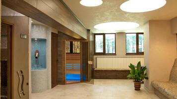 A reception area with a tiled wall, a bench, and a potted plant.