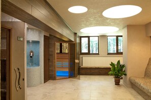 Uma área de recepção com parede revestida de azulejos, um banco e um vaso de planta.