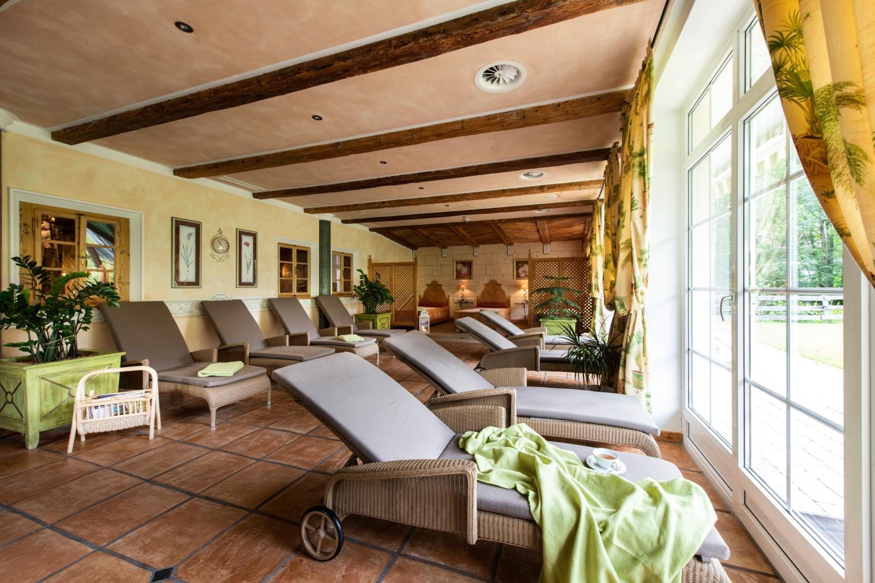 Ein sonnendurchfluteter Raum mit mehreren Loungesesseln und Blick ins Freie.