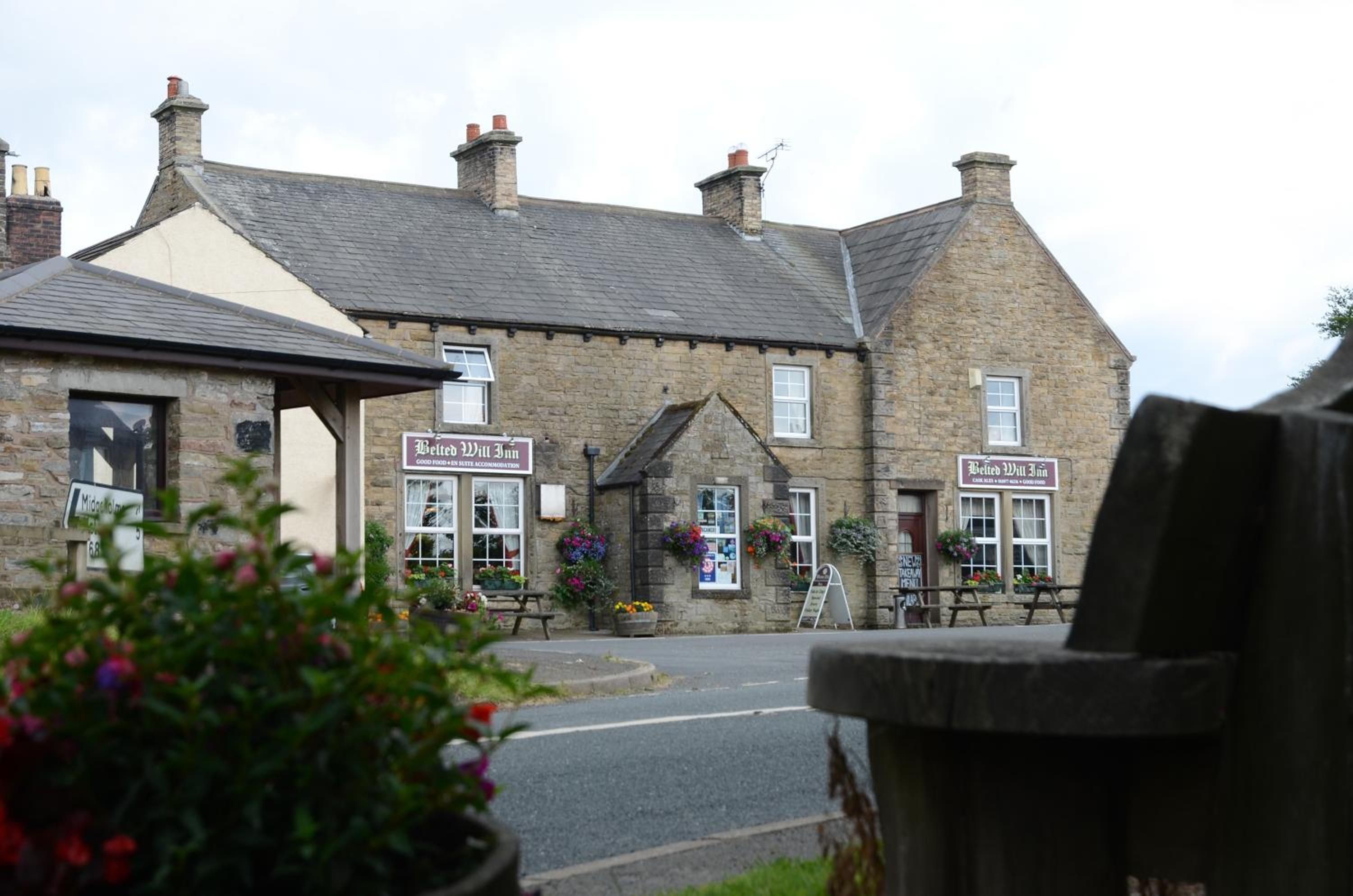 A traditional stone building with a sign indicating it is a bed and breakfast.