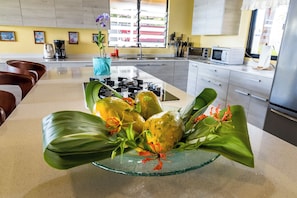 A kitchen with a central island, a microwave, and a sink.
