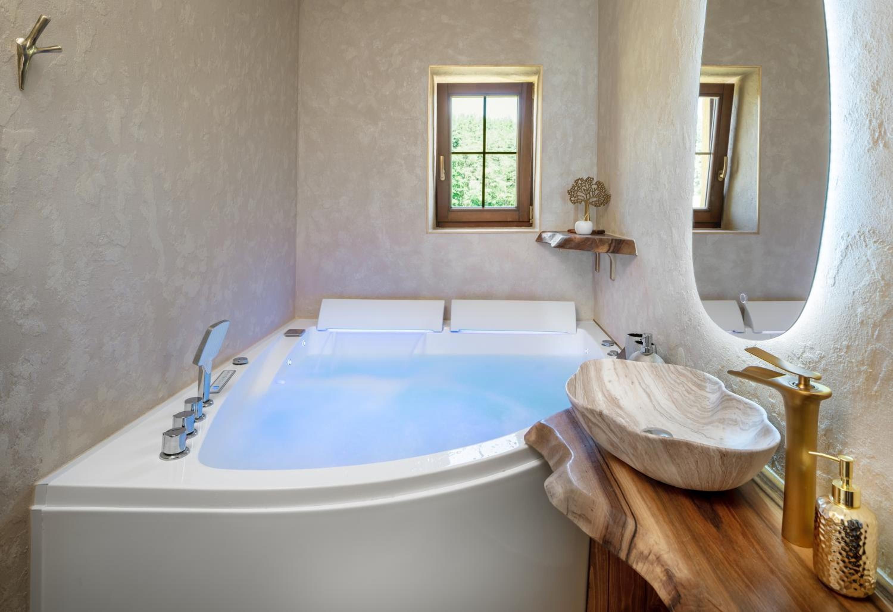 A modern bathroom with a freestanding bathtub, a wooden vanity, and a small window.