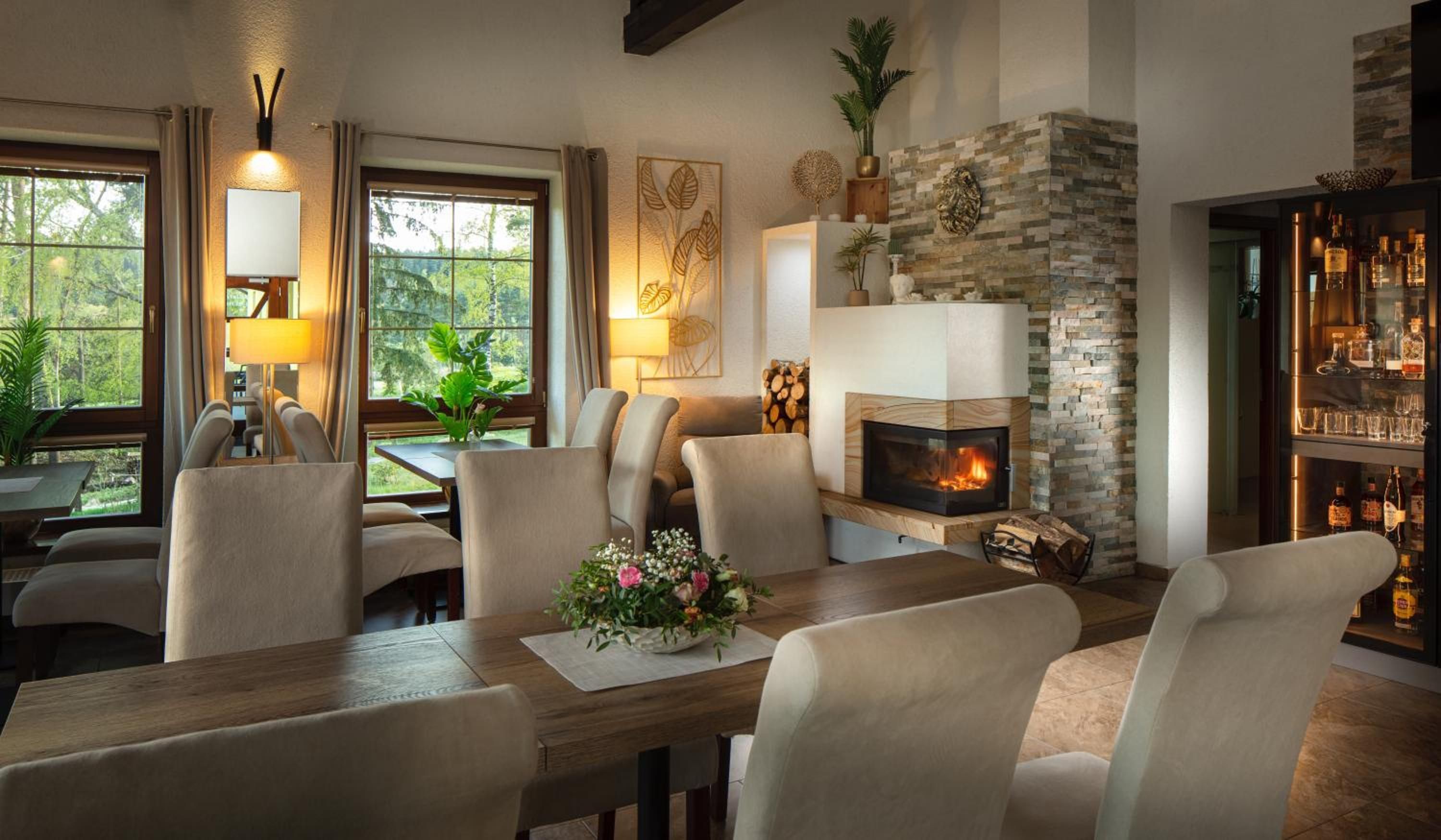 A cozy living room with a fireplace, comfortable seating, and a bar area.
