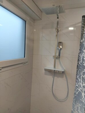 A shower area with a window, a showerhead, and a control panel. - Good Bed Wynau (Wynau)