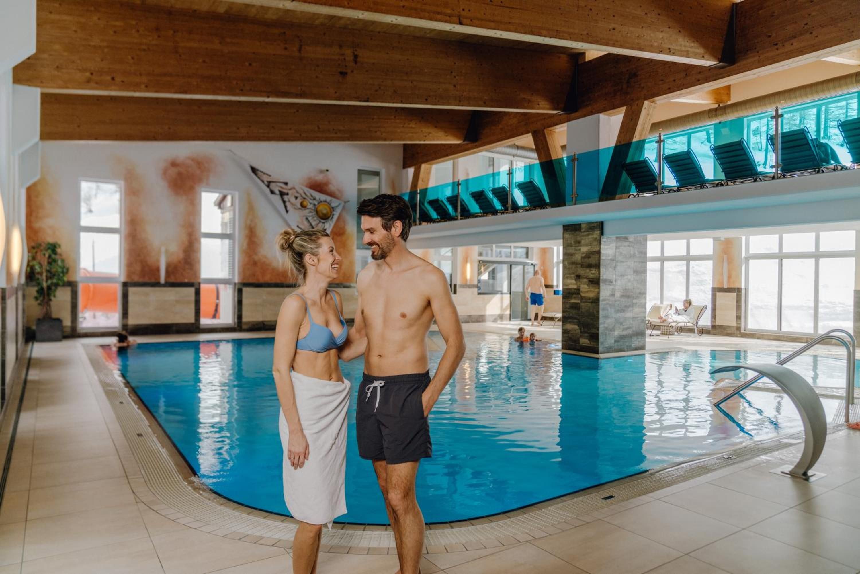 Piscina com design moderno, incluindo um deck superior de vidro e superfície de água translúcida.
