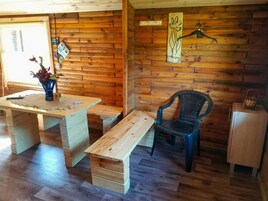 Un interno in legno con una panca, una sedia e un tavolino.