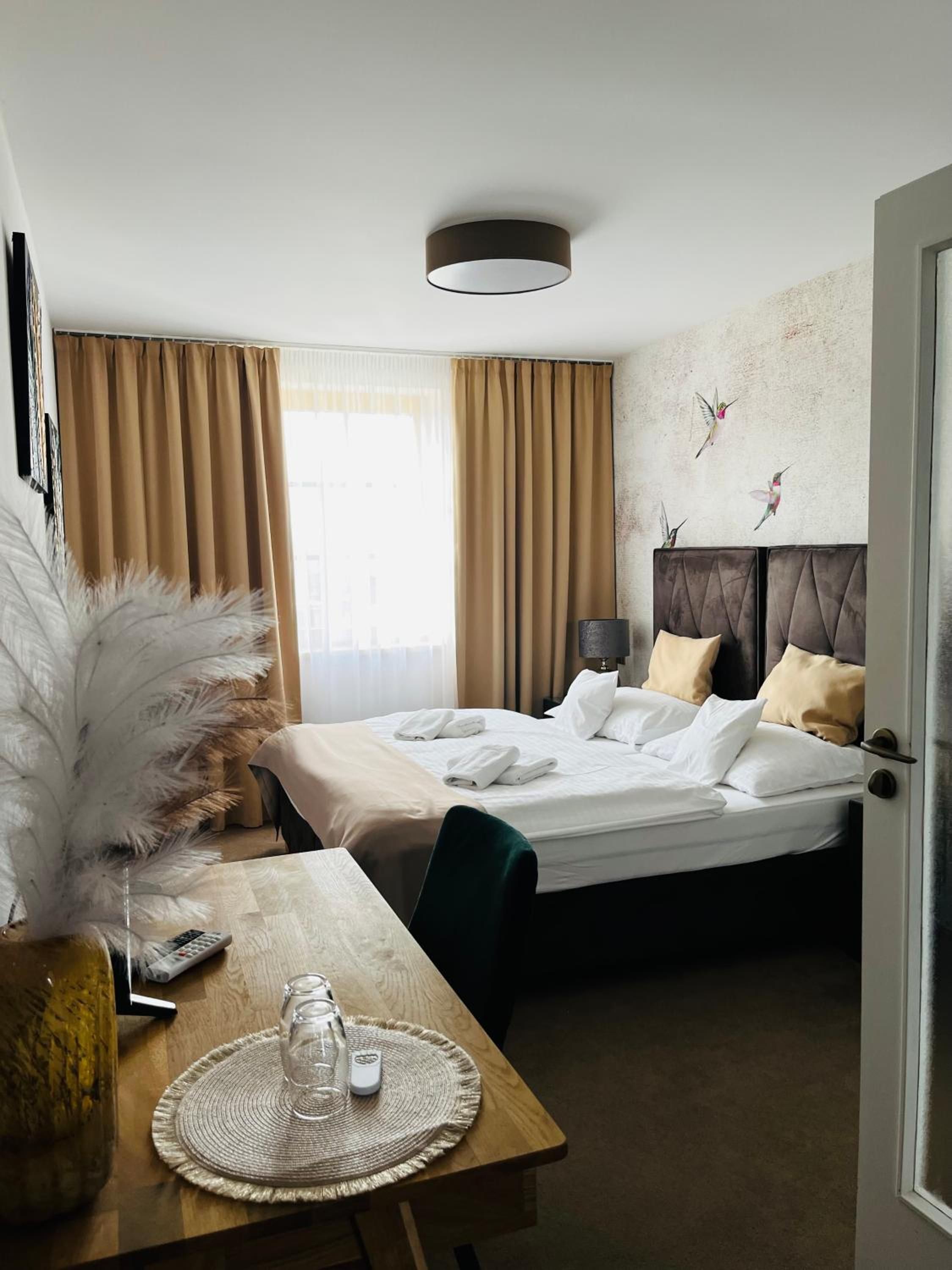 Ein Hotelzimmer mit einem Bett, einem Nachttisch und Blick auf die Stadt.