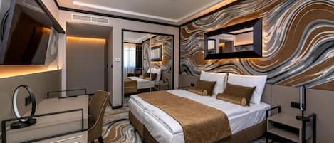 Una habitación de hotel moderna con una cama grande, un escritorio y un espejo.