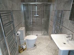 Un baño moderno con ducha de vidrio, inodoro y lavamanos.