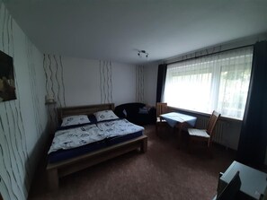 Ein Schlafzimmer mit einem Bett, einem Schreibtisch und einem Stuhl.