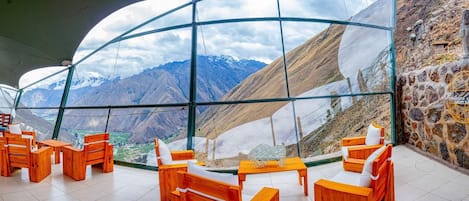 Un ristorante con vista sulle montagne grazie a grandi finestre.