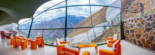 Un restaurante con vistas a montañas a través de amplios ventanales.