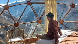 A room with a geometric glass ceiling, a bed, a chair, and a view of mountains. - Vertical Sky Luxury Suites (Ollantaytambo)