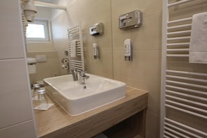 A modern bathroom with a white sink, a mirror, and a towel rack. - Burg Rooms 24h Self Check In (Spielberg)