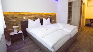 A hotel room with a bed, a nightstand, a wooden headboard, and a wardrobe. - Burg Rooms 24h Self Check In (Spielberg)