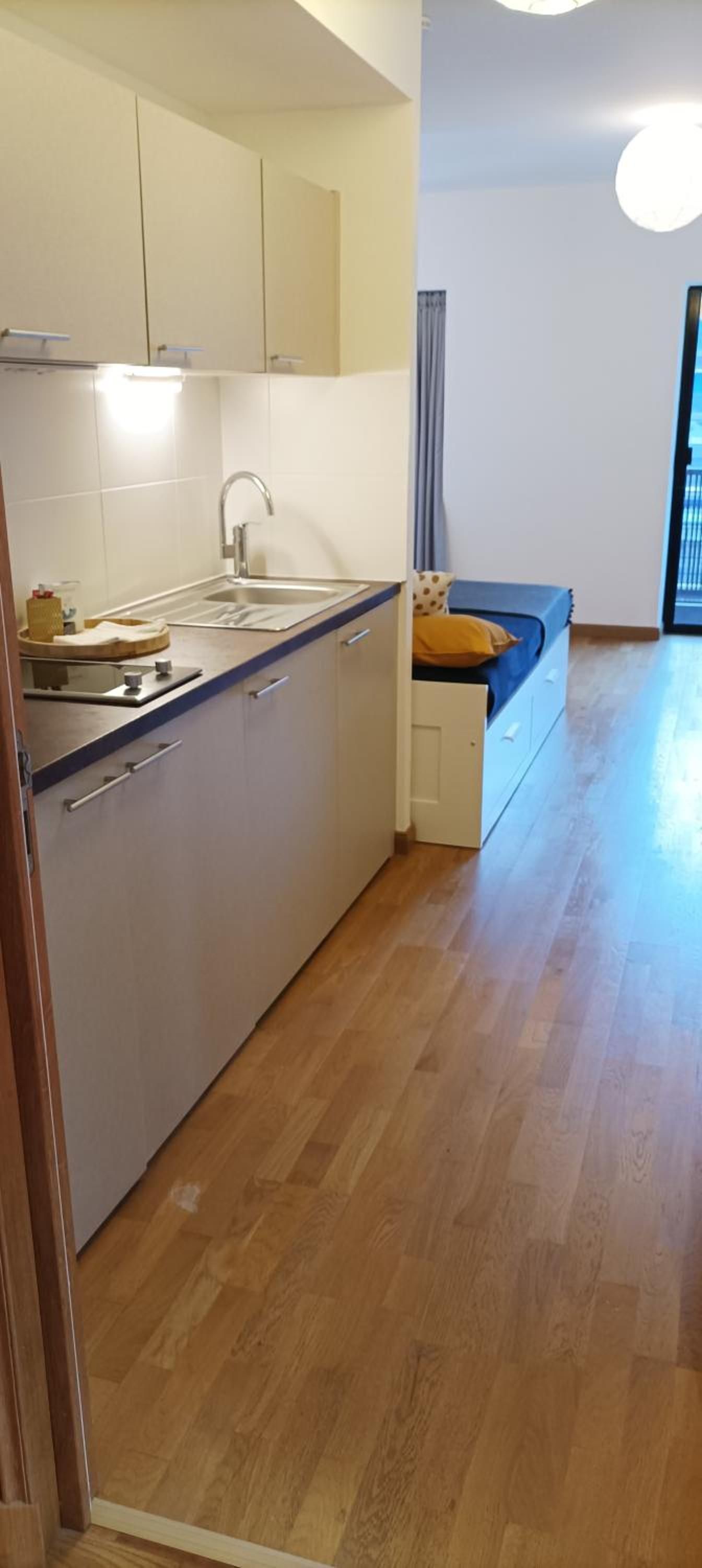 A modern kitchen with a built-in sink, cabinets, and a wooden countertop.