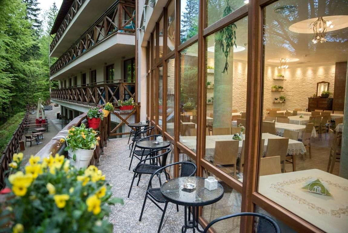Hotel com área de estar ao ar livre e vista para o espaço de refeições interno.