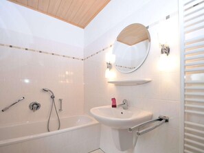 Un baño moderno con bañera, lavamanos y ducha.