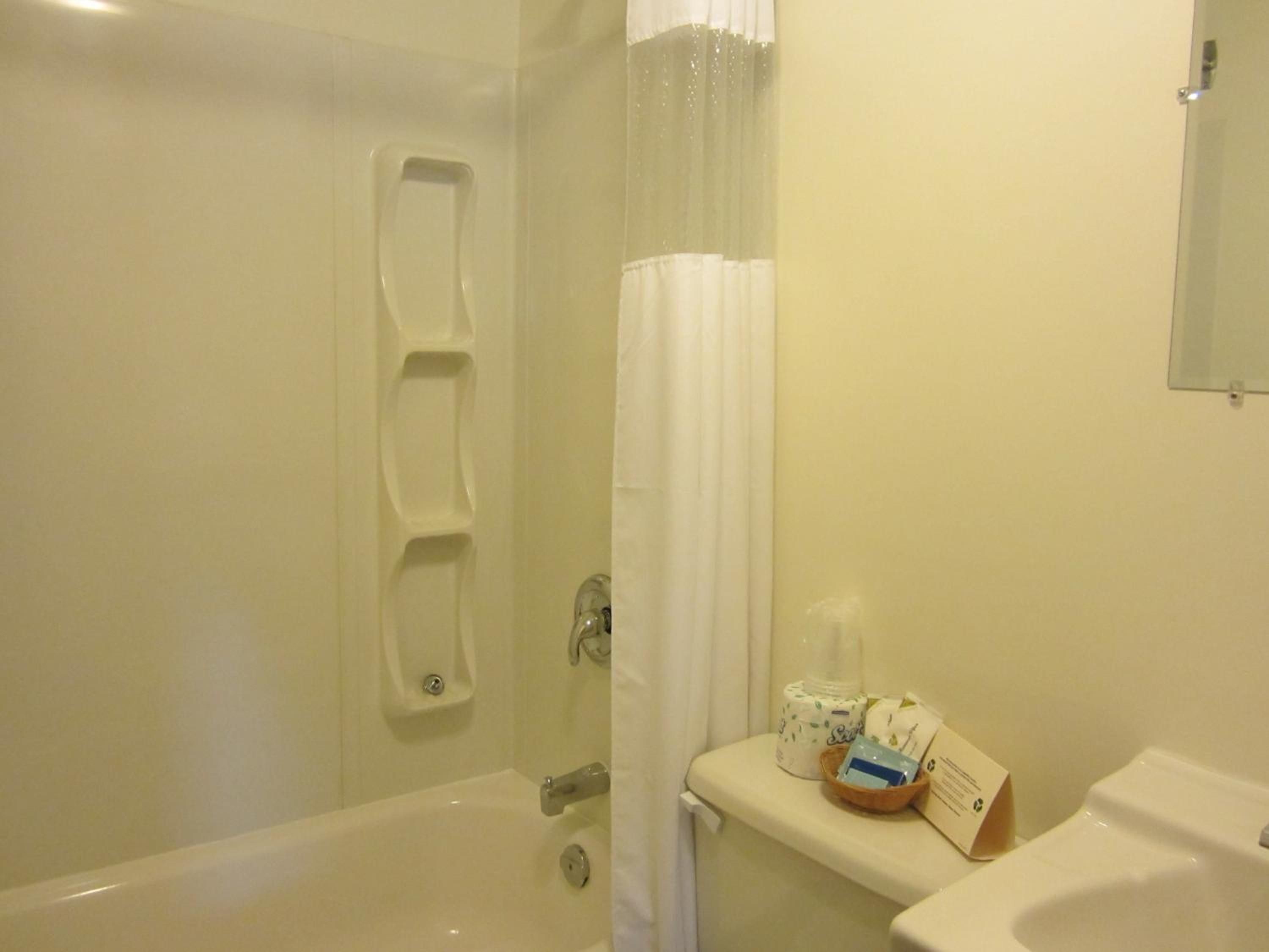 Un baño con bañera, inodoro y cortina de ducha.