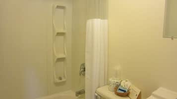 A bathroom with a bathtub, toilet, and shower curtain.